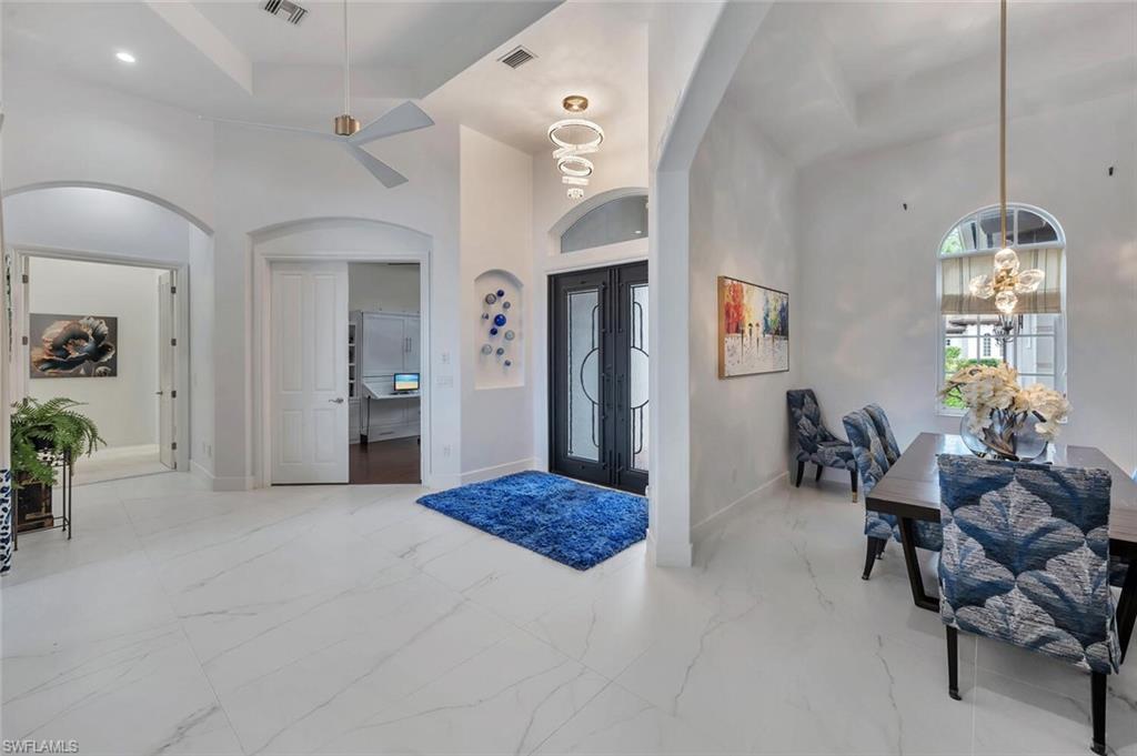 8957 Shenendoah Circle Naples, FL 34113 - Photo 10 of 50 a living room with furniture and a chandelier