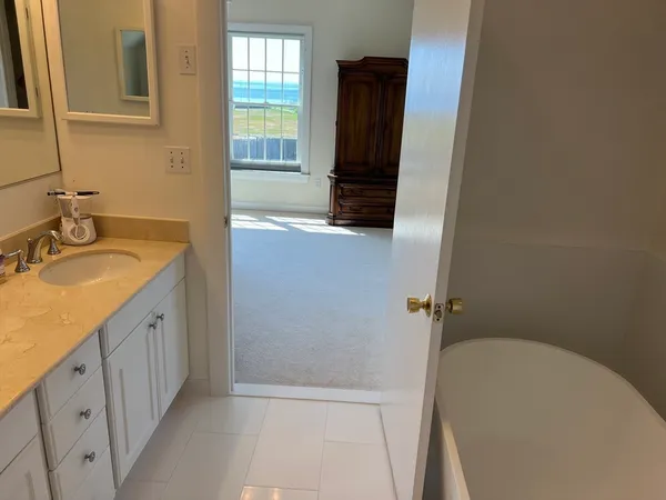 a bathroom with a granite countertop sink a mirror and a bathtub