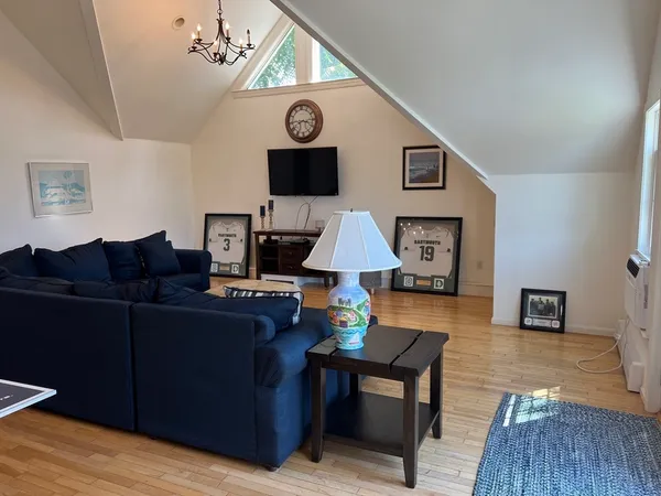 a living room with furniture a clock on wall and a window