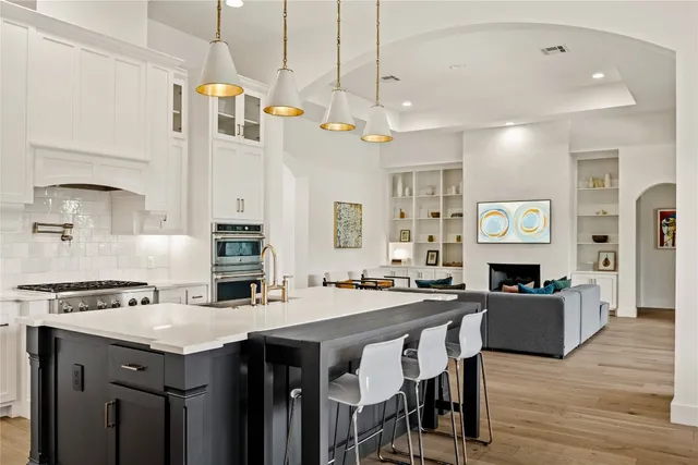 a kitchen with a table chairs sink and cabinets
