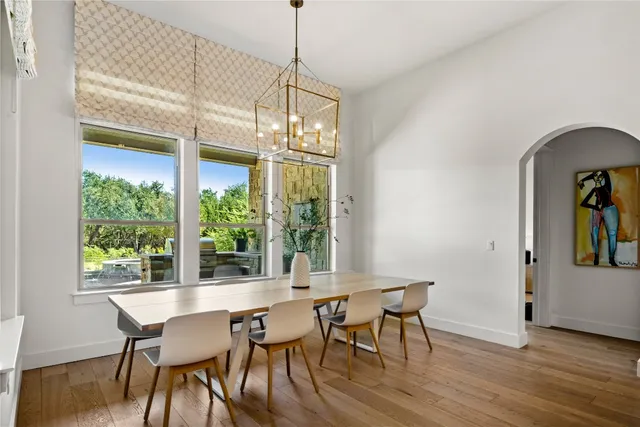 a dining room with furniture a chandelier and wooden floor