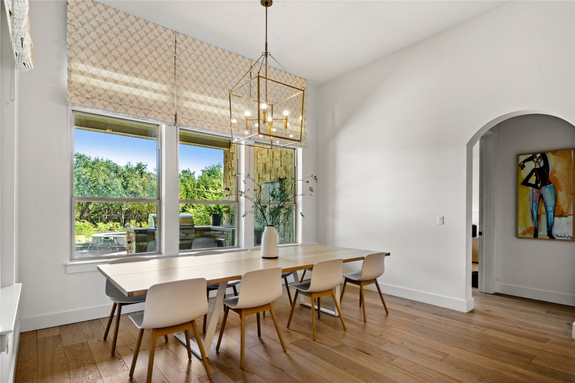 7909 Orisha Drive Austin, TX 78739 - Photo 12 of 40 a dining room with furniture a chandelier and wooden floor