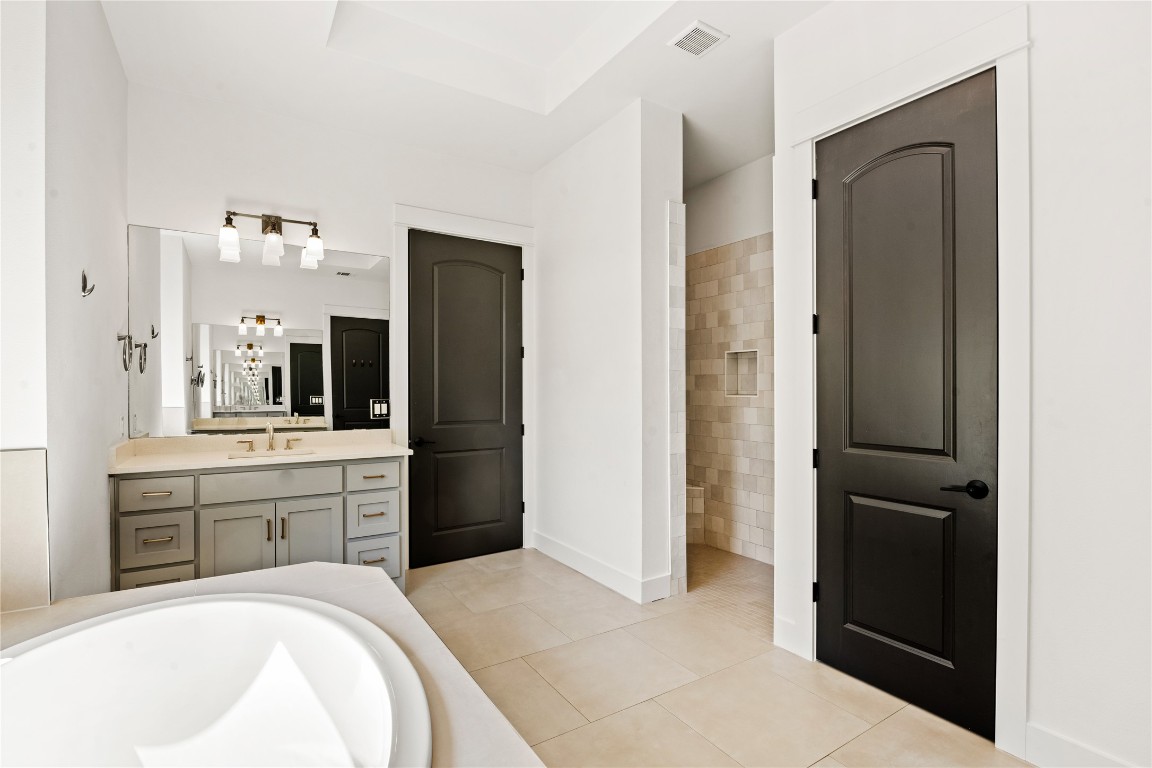 7909 Orisha Drive Austin, TX 78739 - Photo 18 of 40 a spacious bathroom with a bathtub sink and mirror