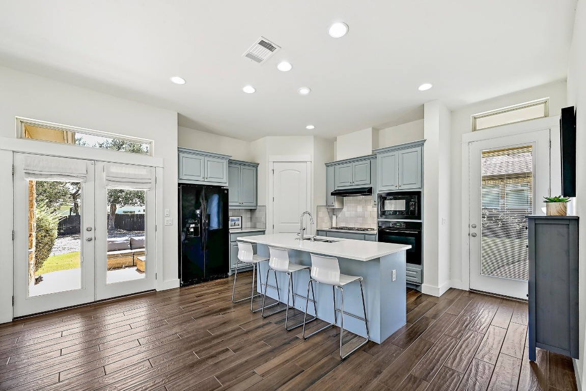 7909 Orisha Drive Austin, TX 78739 - Photo 30 of 40 a kitchen with stainless steel appliances a stove top oven a refrigerator a sink and a refrigerator