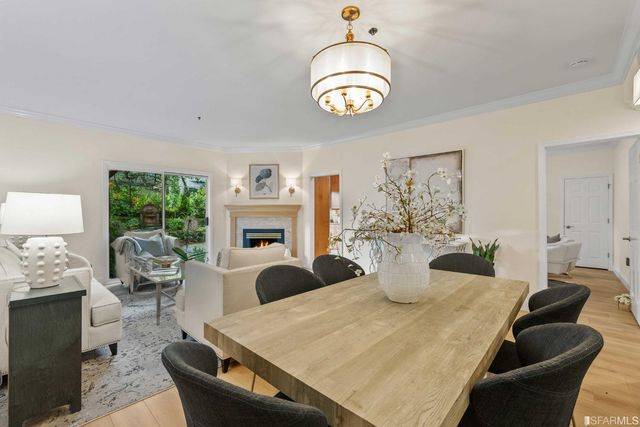 a view of a dining room with furniture a chandelier and window
