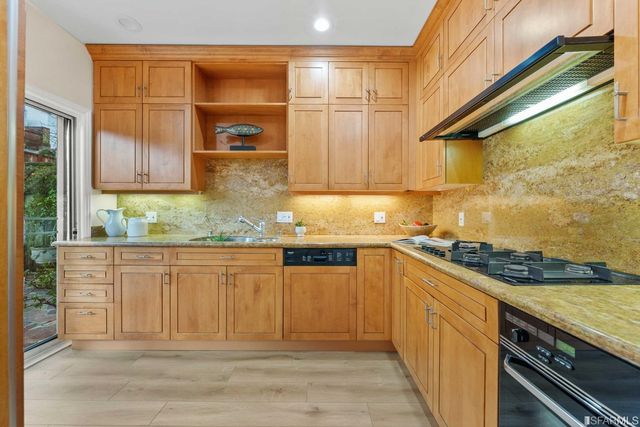 a kitchen with granite countertop cabinets stainless steel appliances and a counter space