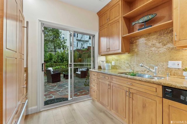 a kitchen with granite countertop a sink and a wooden floor