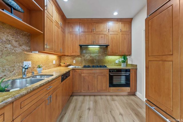 a kitchen with stainless steel appliances granite countertop wooden cabinets and a counter top space