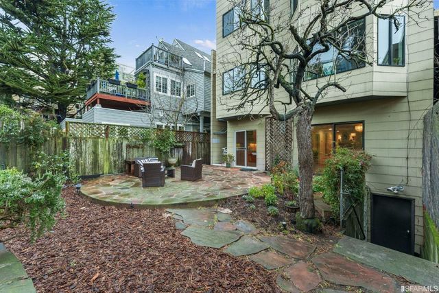 a view of a brick house with a yard and plants