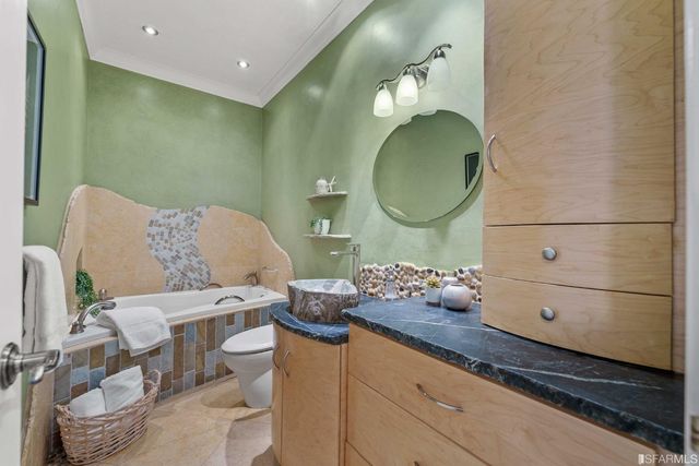 a bathroom with a granite countertop toilet and a mirror