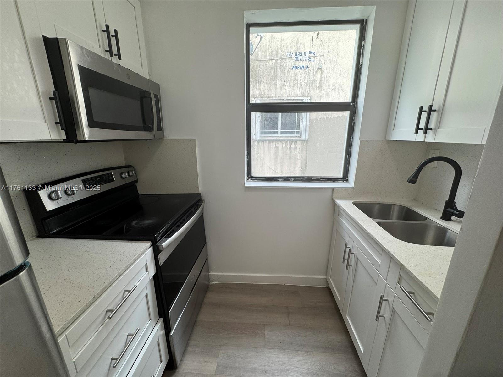 1936 Southwest 2nd Street, Unit 9 Miami, FL 33135 - Photo 2 of 14 a kitchen with a stove and a microwave