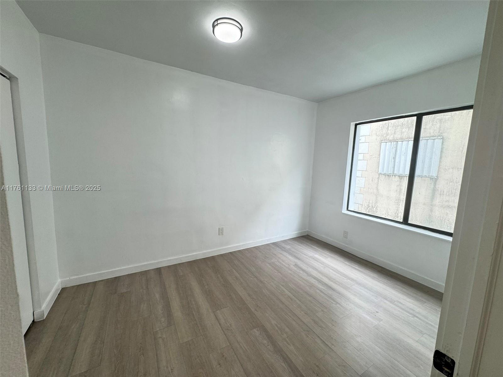 1936 Southwest 2nd Street, Unit 9 Miami, FL 33135 - Photo 10 of 14 an empty room with wooden floor and windows