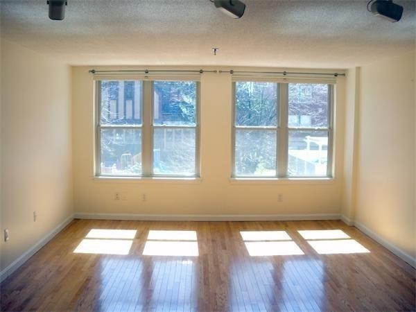 20 Webster Street, Unit 211 Brookline, MA 02446 - Photo 3 of 8 a view of empty room with wooden floor and fan