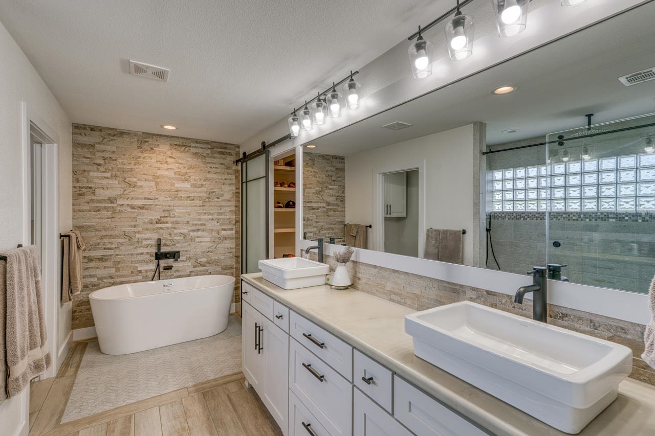 3305 Close Call Horseshoe Bay, TX 78657 - Photo 14 of 30 a bathroom with a double vanity sink a mirror and a bathtub