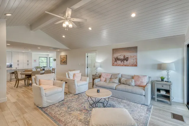 a kitchen with stainless steel appliances granite countertop a table chairs sink refrigerator and cabinets