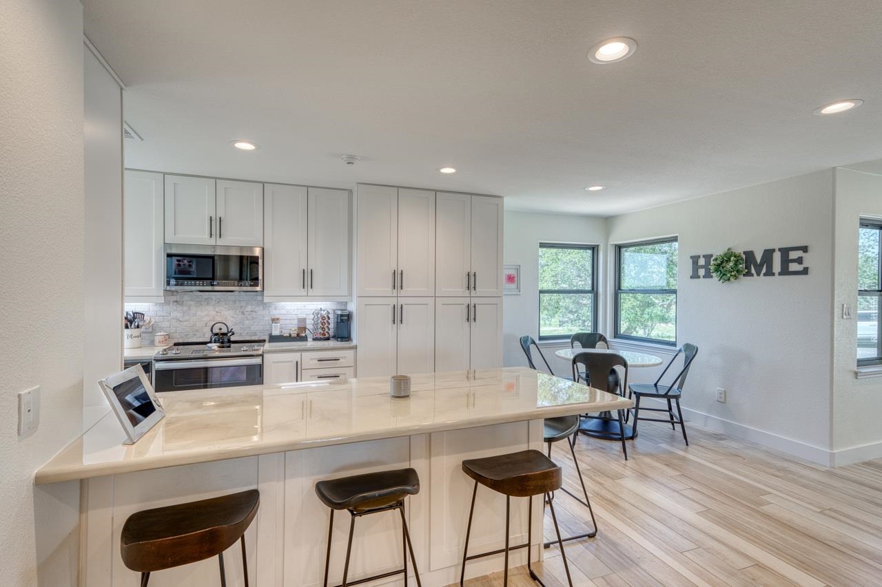 3305 Close Call Horseshoe Bay, TX 78657 - Photo 6 of 30 a kitchen with stainless steel appliances granite countertop a table chairs sink refrigerator and cabinets
