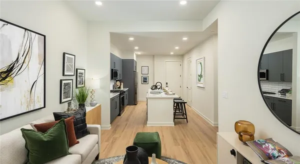 a living room with furniture a flat screen tv and a wooden floor