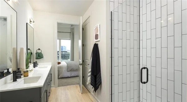a en suite bathroom with a double vanity sink and glass door