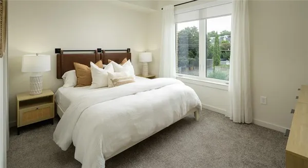 a bed sitting in a bedroom next to a window