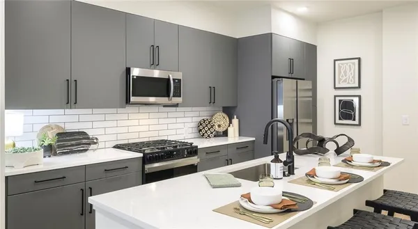 a kitchen with stainless steel appliances kitchen island sink refrigerator and stove