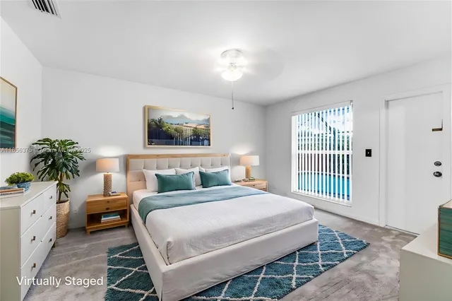 a bedroom with a bed a mirror on dresser and a window