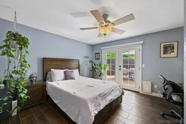 a bedroom with a bed a ceiling fan and a window