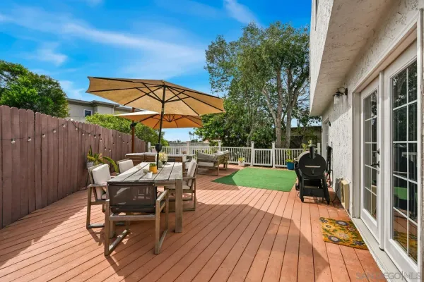 a view of deck with table and chairs under an umbrella with wooden floor