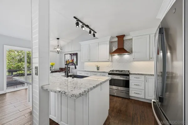 a kitchen with stainless steel appliances granite countertop a sink stove and refrigerator