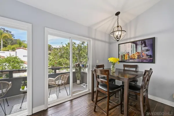 a view of a dining room with furniture a chandelier and wooden floor