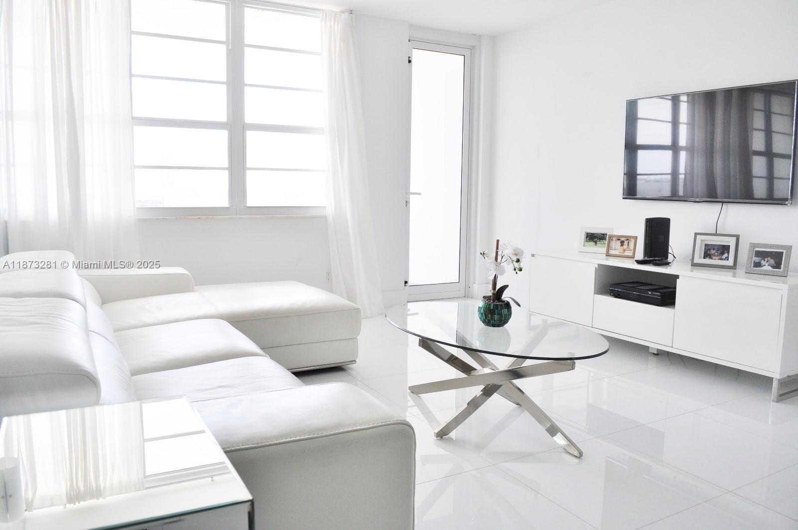 100 Lincoln Road, Unit 1504 Miami Beach, FL 33139 - Photo 1 of 12 a living room with furniture and a table