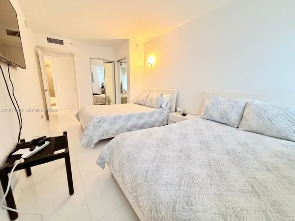 a large white bed in a white room