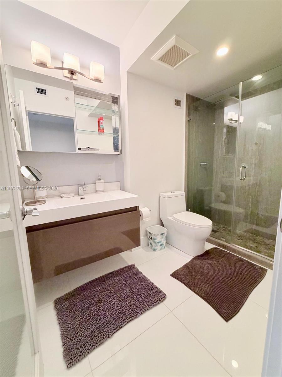 100 Lincoln Road, Unit 1504 Miami Beach, FL 33139 - Photo 9 of 15 a bathroom with a sink a toilet and shower