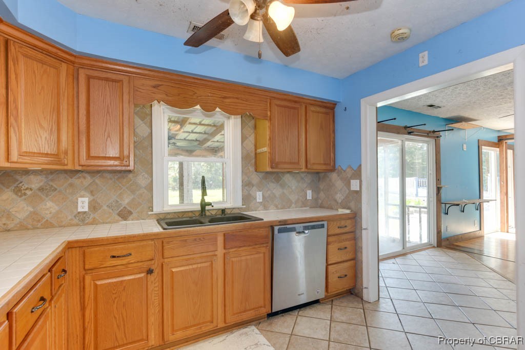 2584 Starvation Road Gloucester, VA 23061 - Photo 18 of 38 Kitchen with dishwasher, light tile patterned floors, tile countertops, sink, and ceiling fan