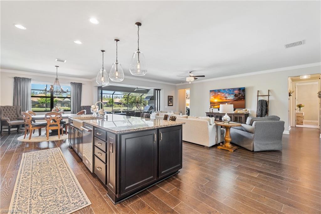 a kitchen with stainless steel appliances granite countertop a stove and a living room view