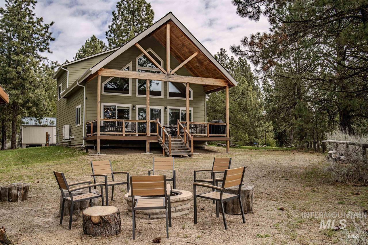 Wood-sided residence featuring a prominent covered porch with exposed beams and a large deck