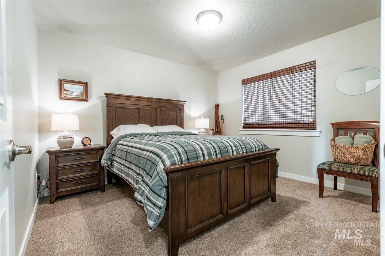 21 Melonie Loop Cascade, ID 83611 - Photo 19 of 27 Carpeted room featuring a window with woven wood blinds, ceiling-mounted lighting, and painted walls