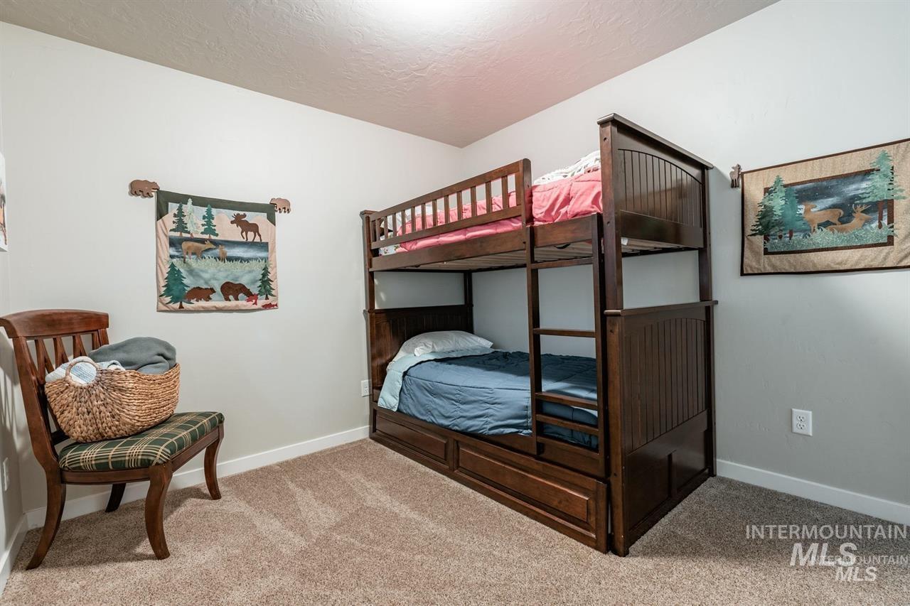21 Melonie Loop Cascade, ID 83611 - Photo 20 of 27 Carpeted room with light-colored walls and a bunk bed featuring a rich wood finish
