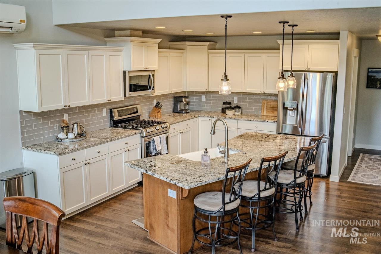 21 Melonie Loop Cascade, ID 83611 - Photo 10 of 27 Kitchen featuring white upper and lower cabinetry, granite countertops, and a subway tile backsplash