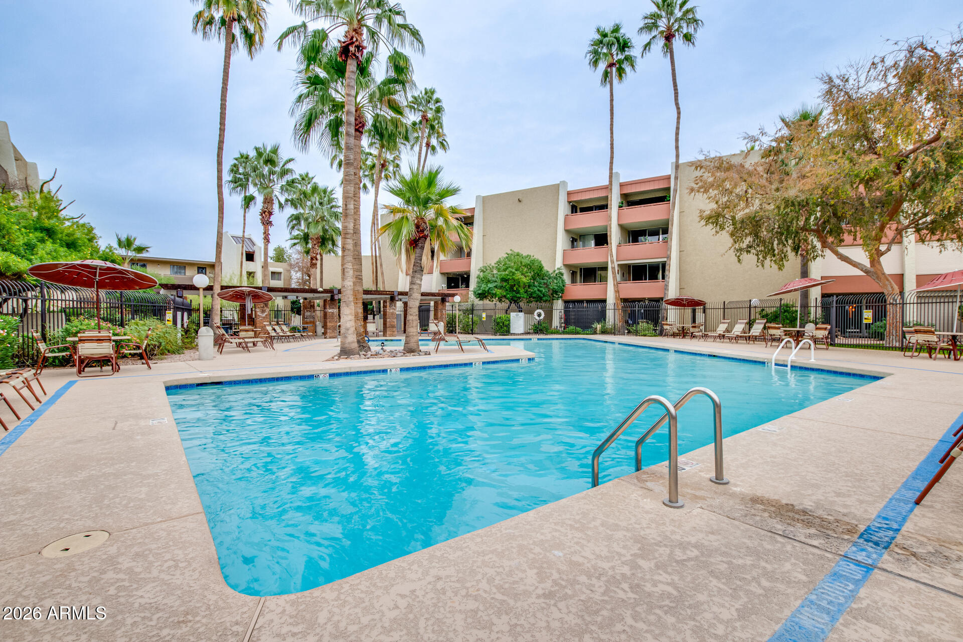 7625 East Camelback Road, Unit A220 Scottsdale, AZ 85251 - Photo 11 of 37 a view of a swimming pool with a lawn chairs