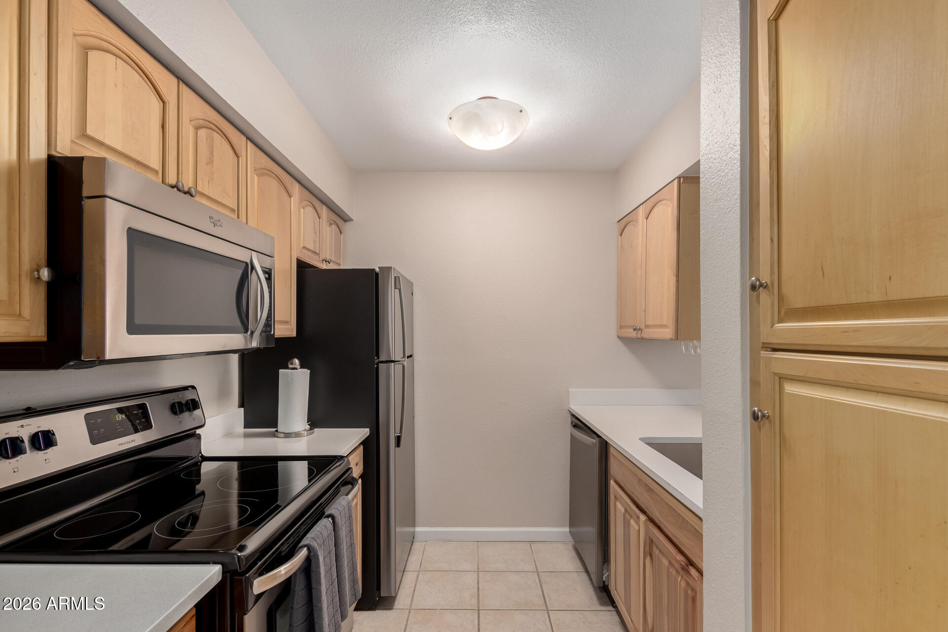 7625 East Camelback Road, Unit A220 Scottsdale, AZ 85251 - Photo 17 of 37 a kitchen with stainless steel appliances a stove microwave and a refrigerator