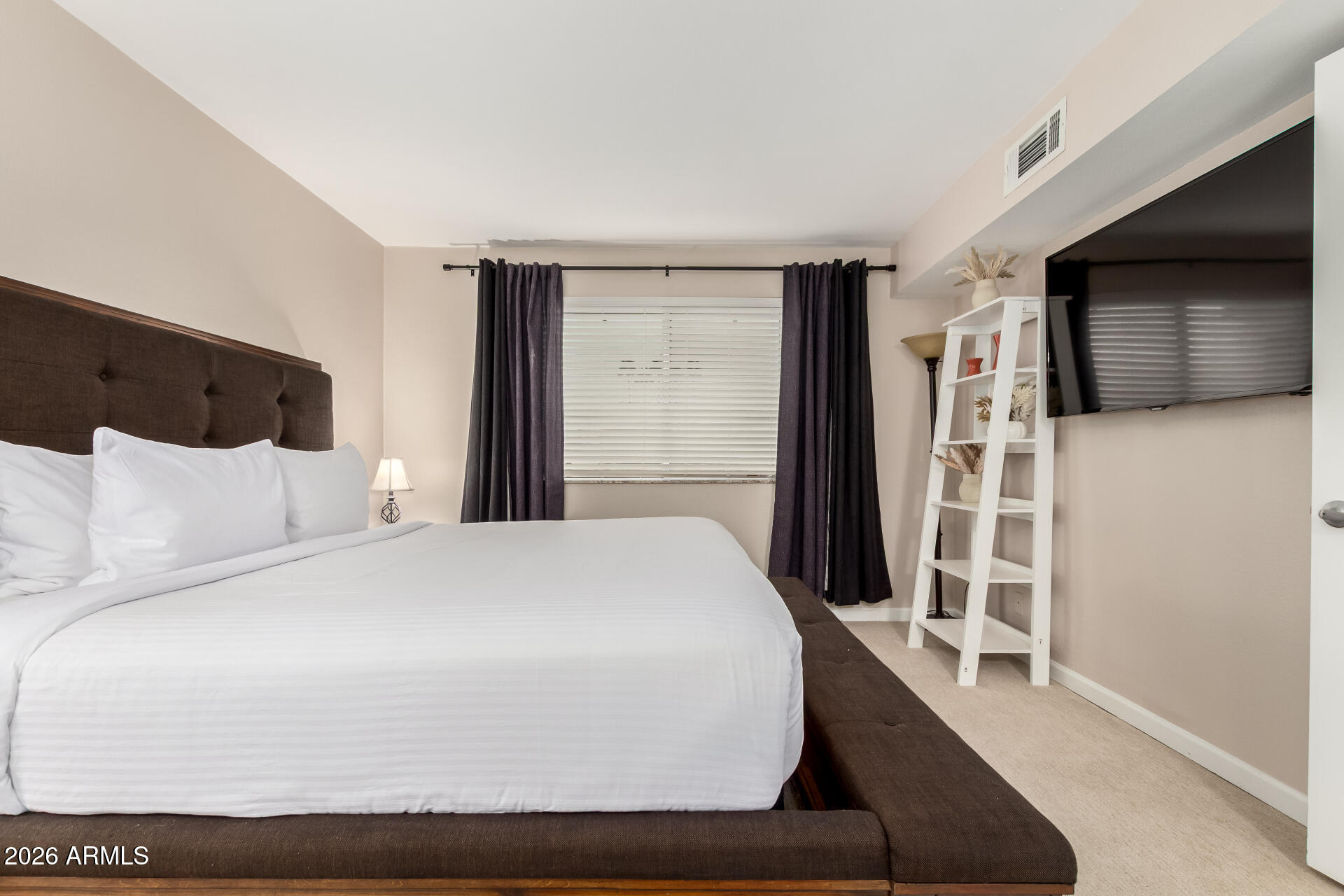 7625 East Camelback Road, Unit A220 Scottsdale, AZ 85251 - Photo 23 of 37 a bedroom with a large bed and a flat tv screen on dresser