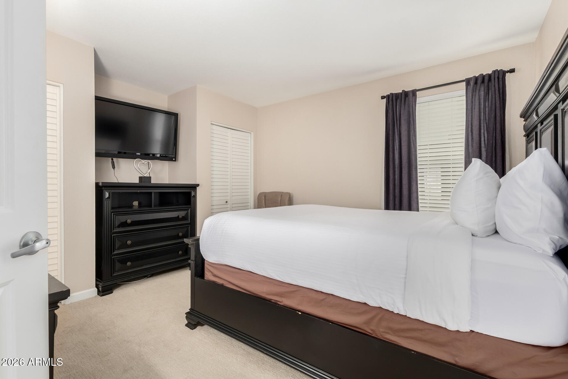 7625 East Camelback Road, Unit A220 Scottsdale, AZ 85251 - Photo 27 of 37 a bedroom with a bed and a flat screen tv