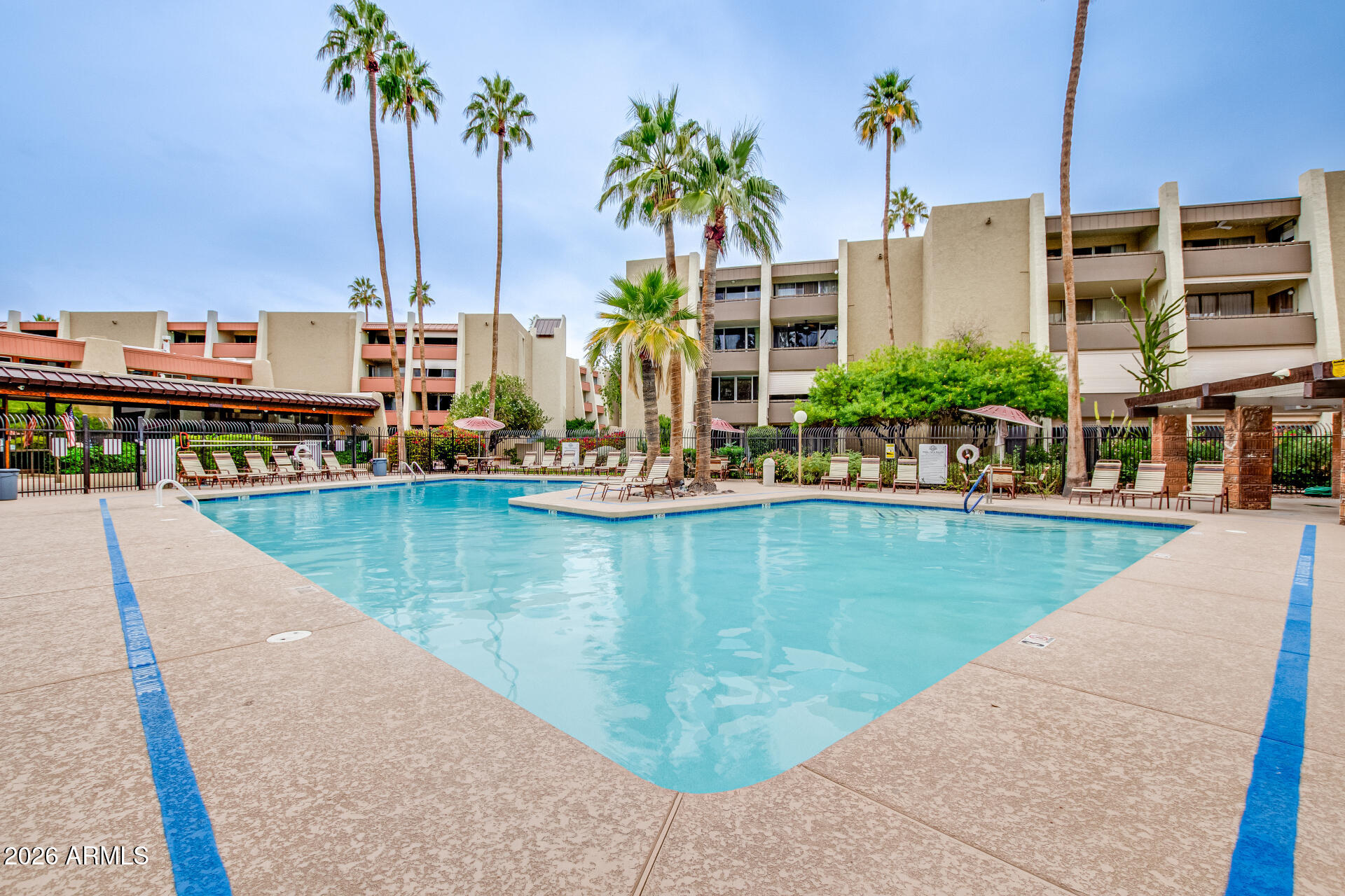 7625 East Camelback Road, Unit A220 Scottsdale, AZ 85251 - Photo 29 of 37 a view of a swimming pool with a lawn chairs