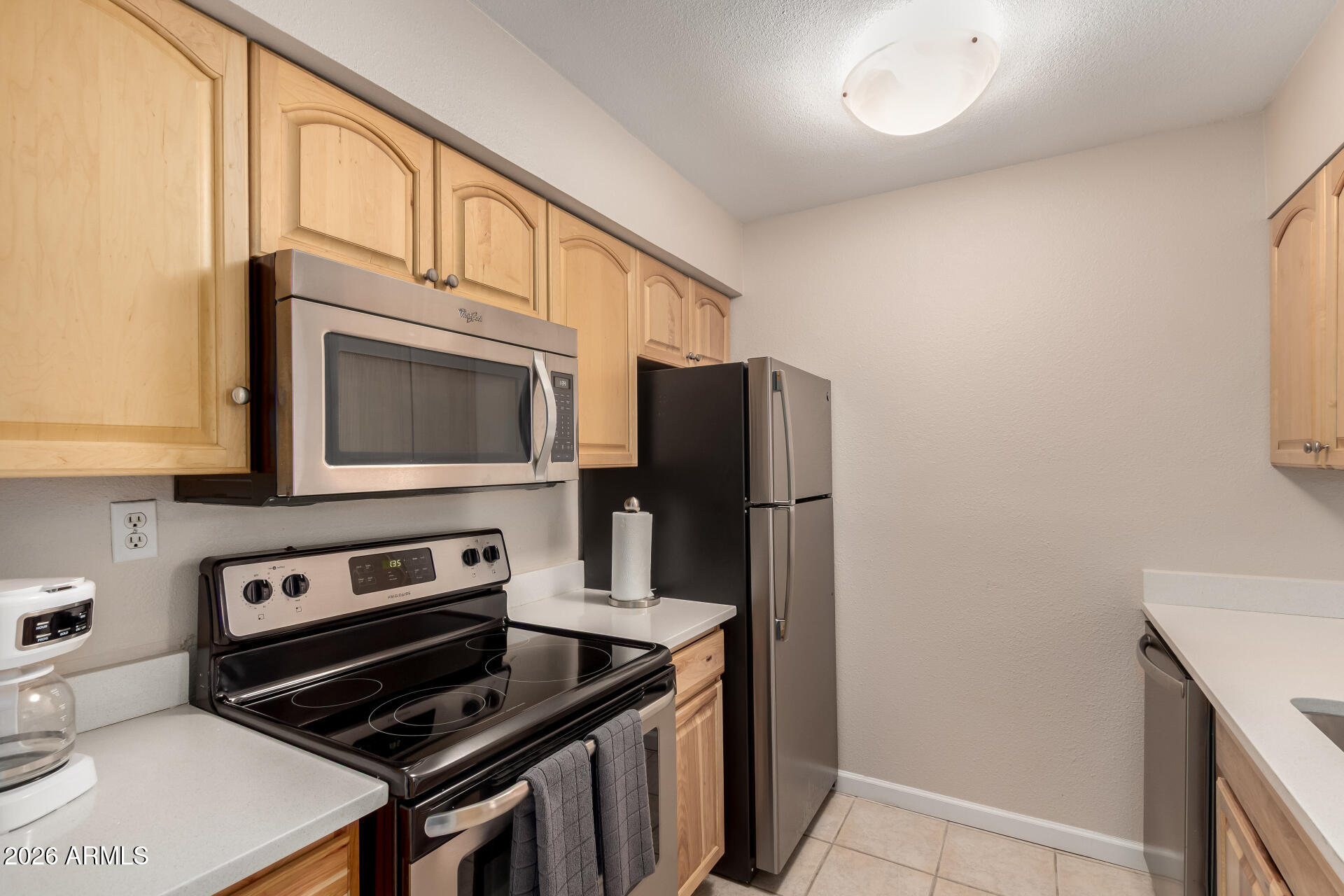 7625 East Camelback Road, Unit A220 Scottsdale, AZ 85251 - Photo 4 of 37 a kitchen with stainless steel appliances a stove a microwave and a refrigerator
