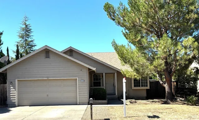 a front view of a house with a tree