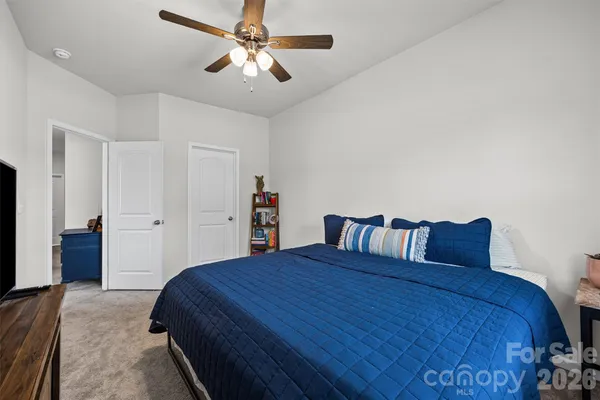 a bed sitting in a spacious bedroom next to a window
