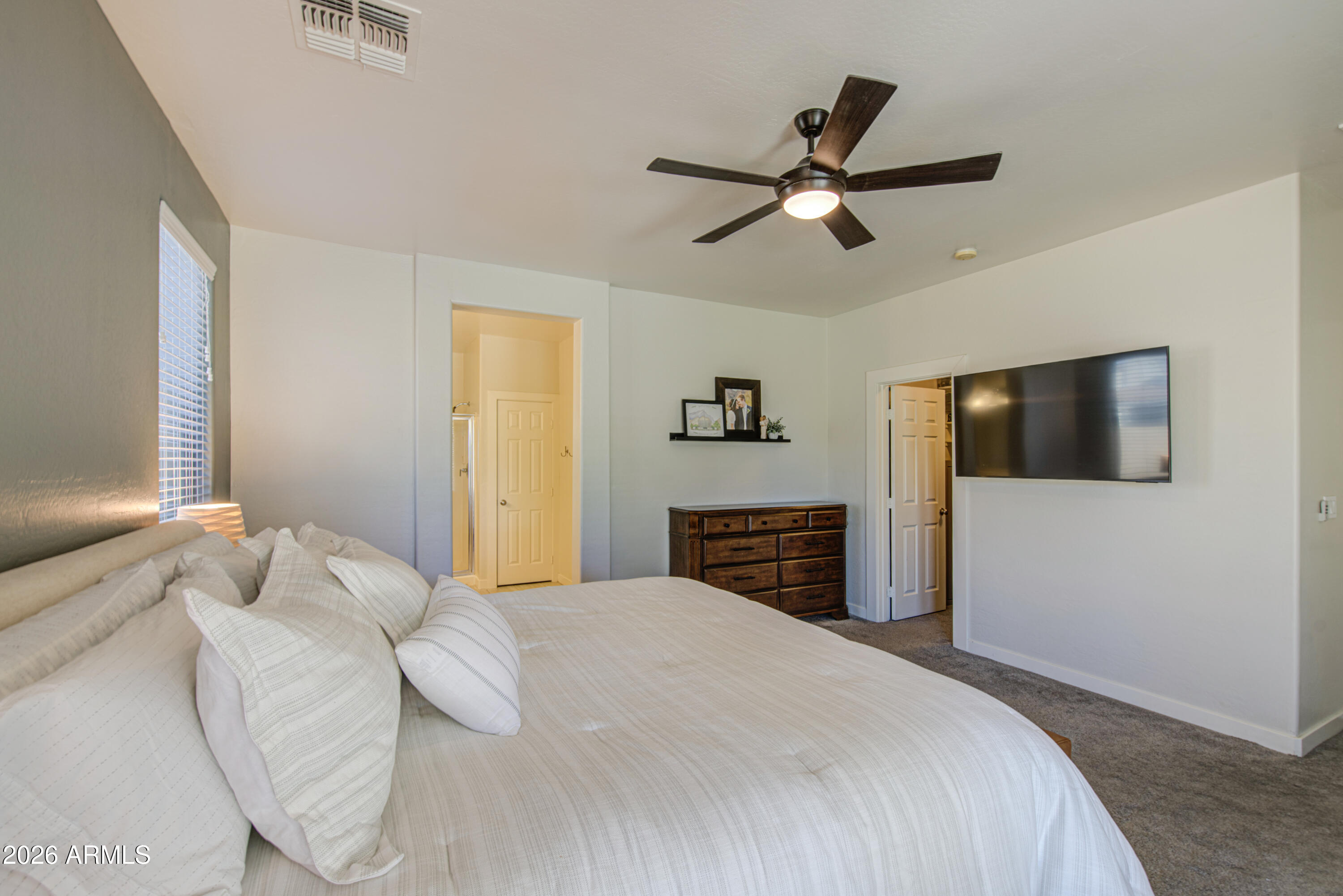 21303 East Alyssa Road Queen Creek, AZ 85142 - Photo 18 of 29 a bedroom with a large bed and a chandelier