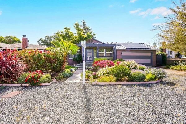 a front view of a house with a yard and outdoor seating