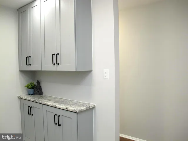 a kitchen with granite countertop white cabinets and a wooden floor