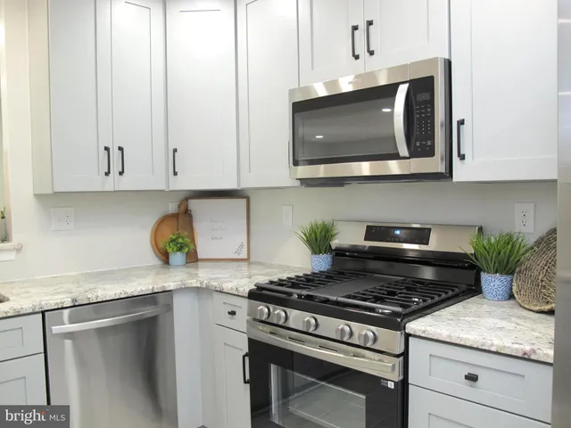 a kitchen with stainless steel appliances granite countertop a stove a microwave and cabinets